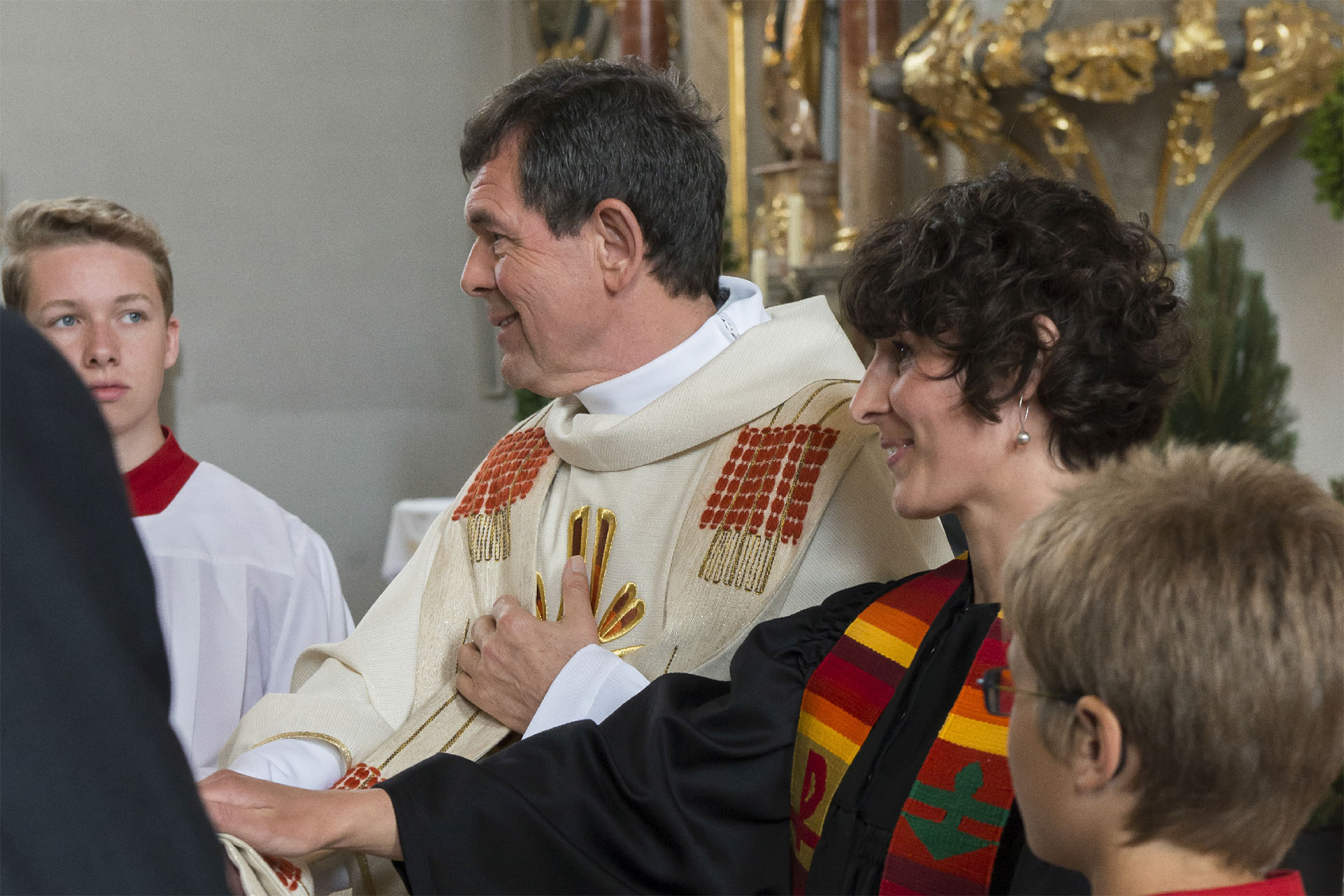 Eine evangelische Pfarrerin und ein katholischer Priester bei einer Trauung. 